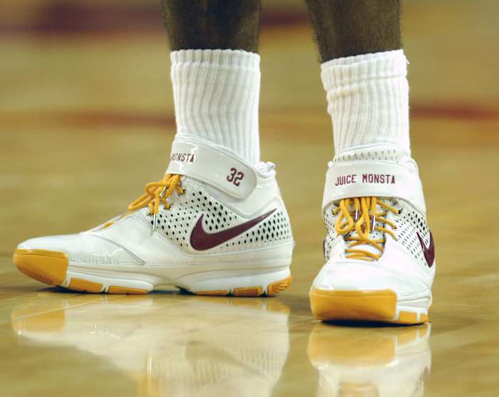 View of white and gold Nike Kobe shoes.